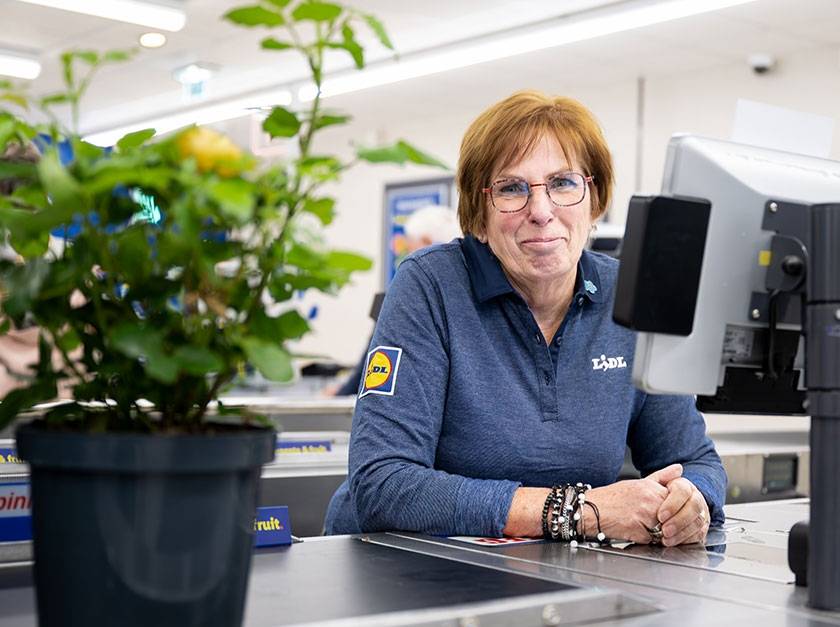Verkoopmedewerker zit achter de kassa