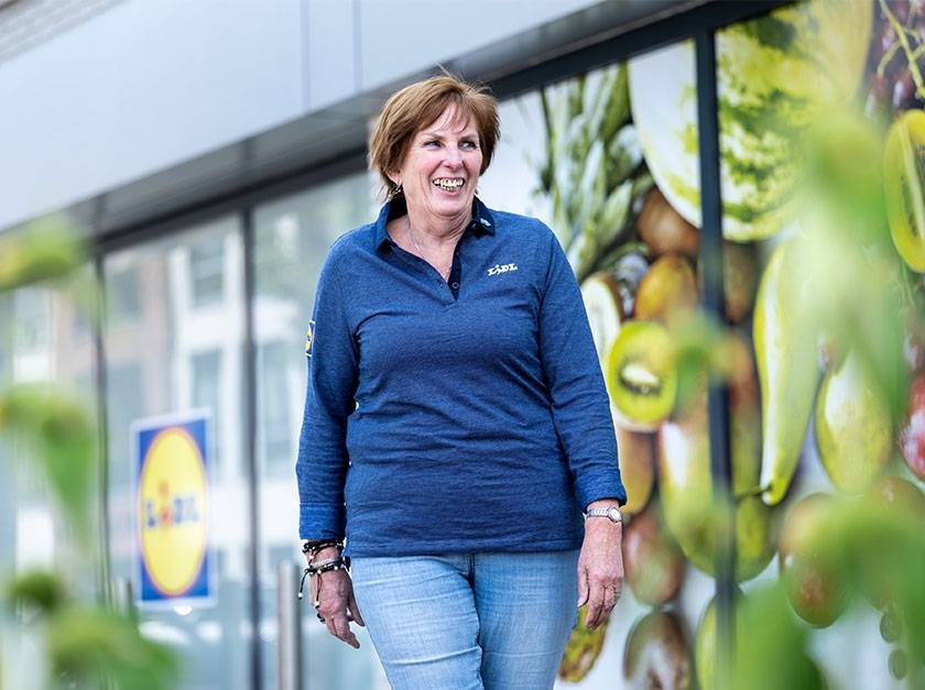Collega verkoopmedewerker loopt buiten filiaal