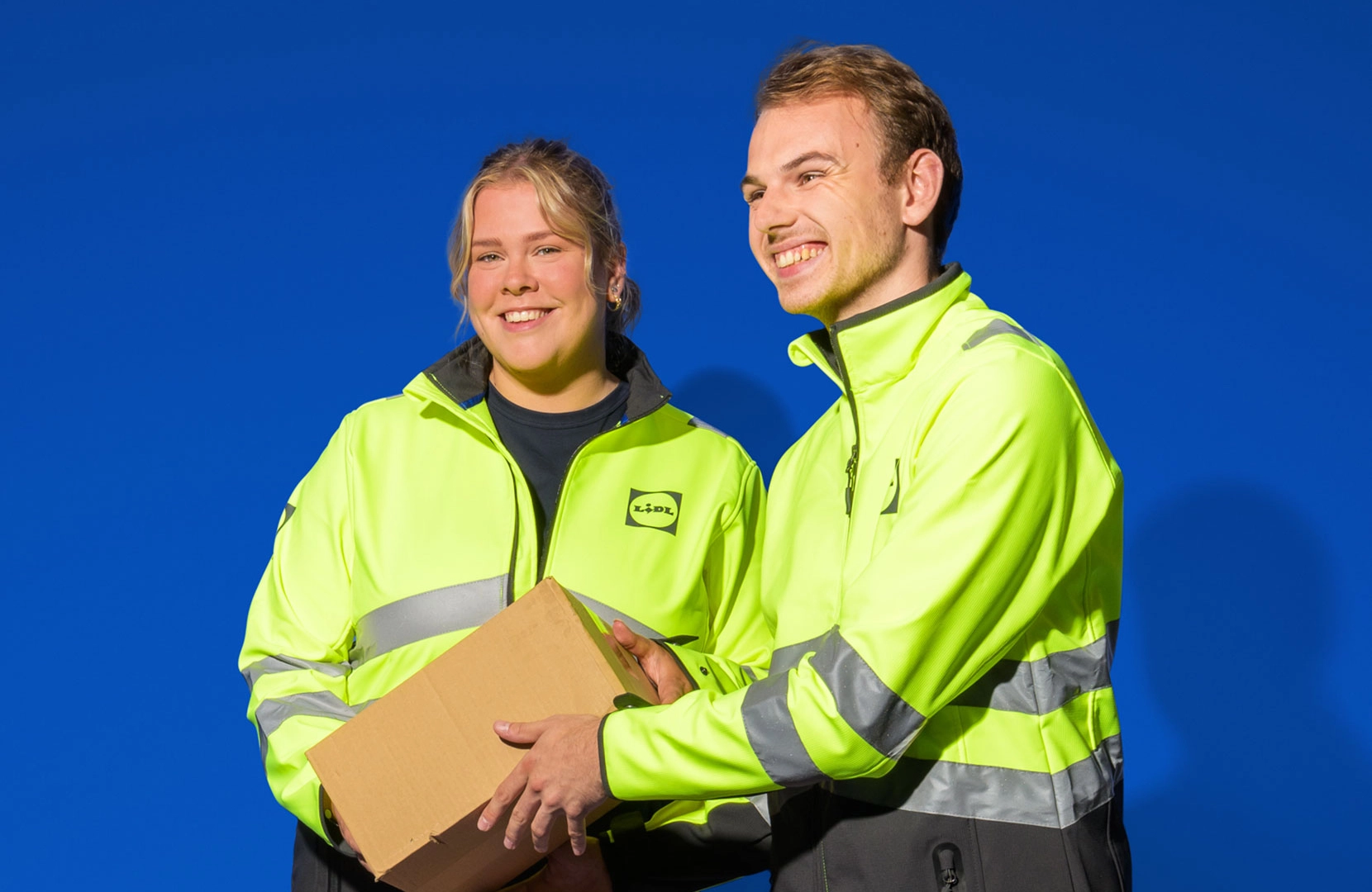 Twee orderpickers houden een doos vast