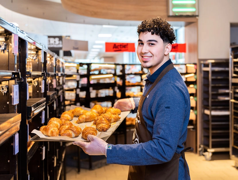 Verkoopmedewerker staat in de bakeoff met croissantjes