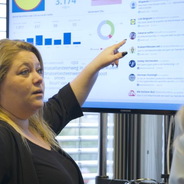 Collega's die naar een webcare scherm kijkt