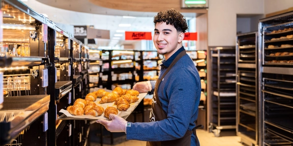 Verkoopmedewerker staat bij de bake-off met tree croissants